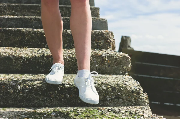 The legs of a woman walking down stairs — Stock Photo, Image