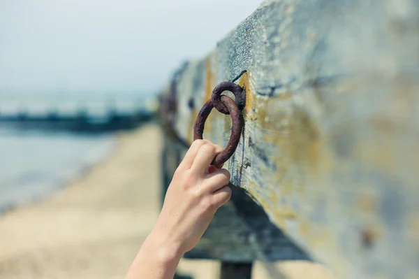 Female hand grabbing rusty chain — Stock Photo, Image