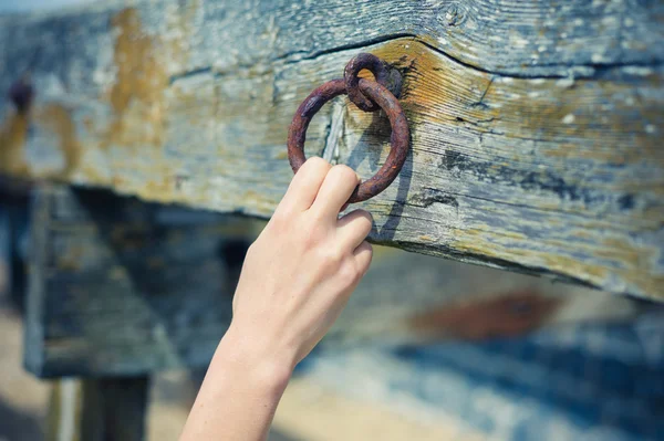 Vrouwelijke hand grijpen roestig keten — Stockfoto