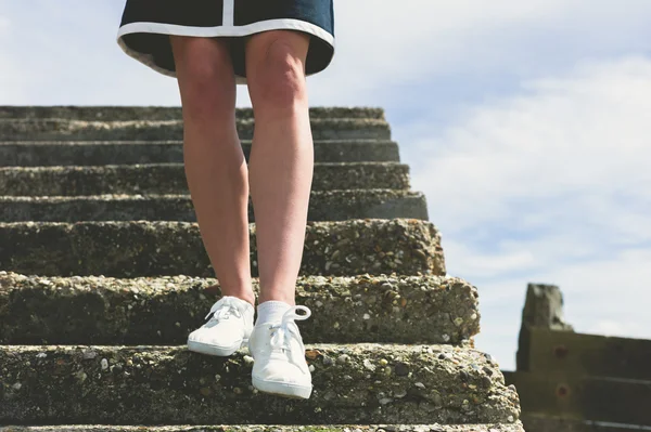 The legs of a woman walking down stairs — Stock Photo, Image