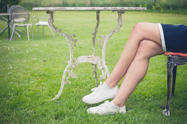 Mulher relaxante na cadeira em um jardim — Fotografia de Stock