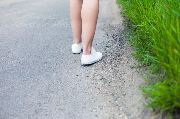 Mujer caminando por la carretera en el campo — Foto de Stock