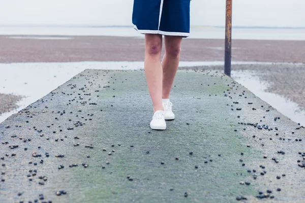 Whelks ile pier üzerine yürüyen kadın