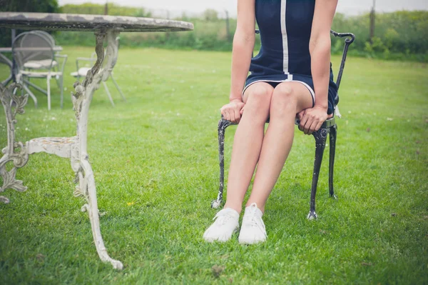 Frau entspannt sich auf Stuhl im Garten — Stockfoto