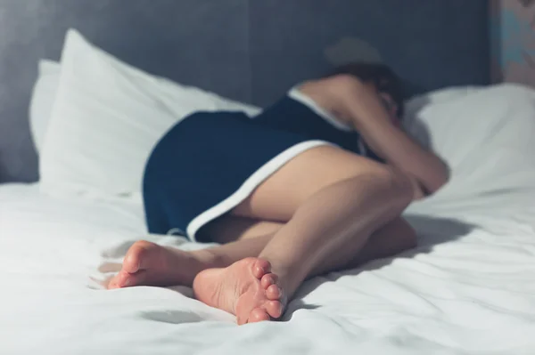 Mujer joven durmiendo en una cama — Foto de Stock