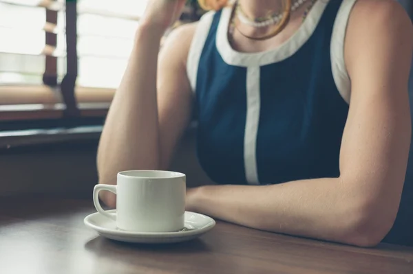 Молодая женщина пьет кофе в закусочной — стоковое фото