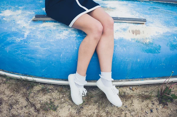 Mujer sentada en un bote junto al mar —  Fotos de Stock