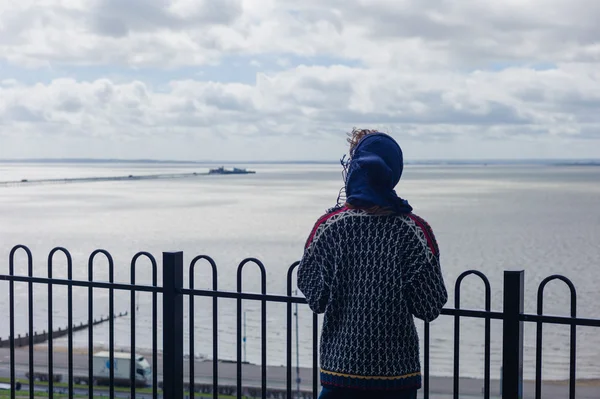 Mulher olhando para um cais à beira-mar — Fotografia de Stock