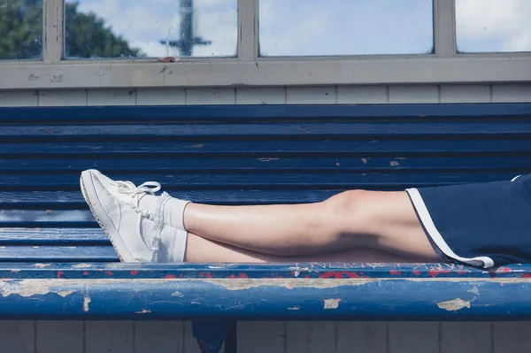 Vrouw liggen op een bankje in de zomer — Stockfoto