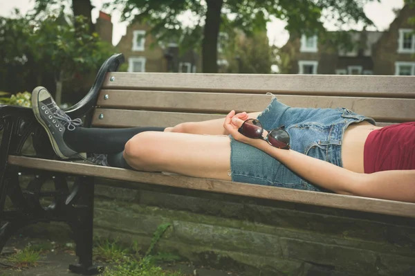 Jovem relaxante no banco do parque — Fotografia de Stock