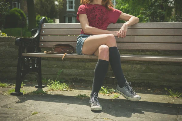 公園のベンチに座っている若い女性 — ストック写真