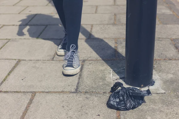 Pies de mujer por poste de lámpara — Foto de Stock