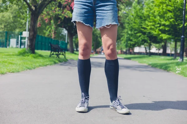 Giovane donna in piedi in un parco — Foto Stock