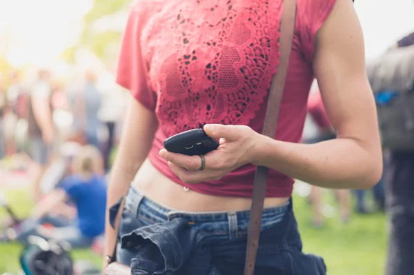 Festivalde Smartphone kullanan genç kadın — Stok fotoğraf