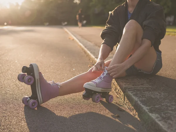 Mujer poniéndose patines en el parque —  Fotos de Stock