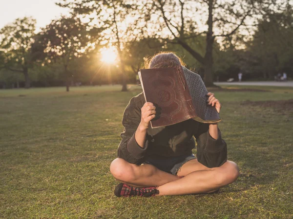 Woman with notebook in park at sunset — Stock Photo, Image