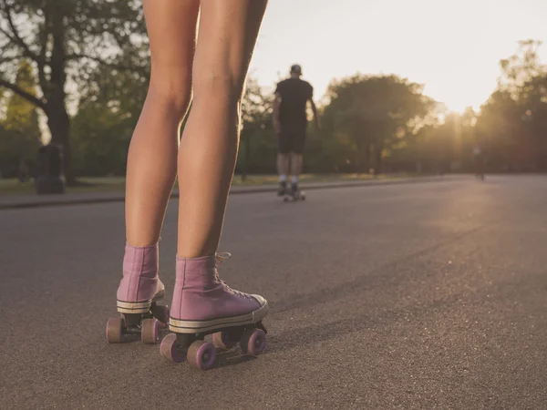 Nohy mladá žena kolečkových bruslích v parku — Stock fotografie