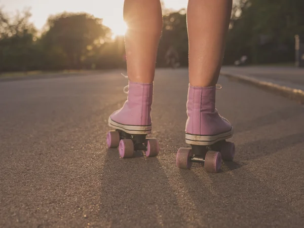 Patas de mujer joven patinaje sobre ruedas en parque — Foto de Stock