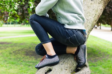 Genç kadın bir ağaçta siting