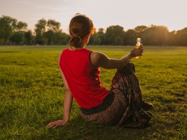 İçme ve günbatımı Park'ta hayran kadın