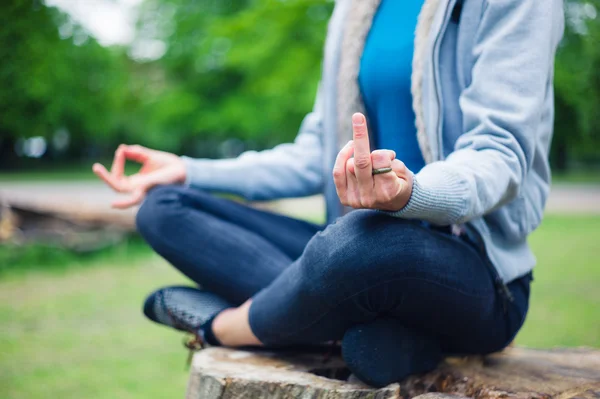 Mujer en meditación pose mostrando gesto grosero —  Fotos de Stock