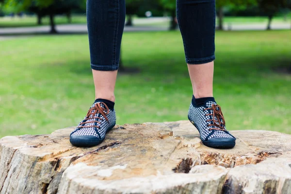 Feet of young woman standing on tree trunk — Stock Photo, Image