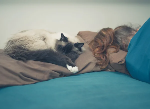 Mujer durmiendo en la cama con gato —  Fotos de Stock