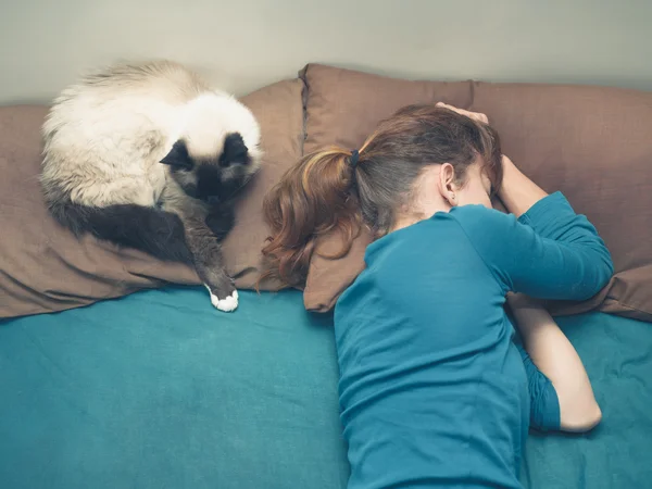 Mujer durmiendo en la cama con gato — Foto de Stock