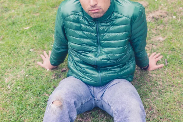 Homem com jeans rasgados na grama — Fotografia de Stock