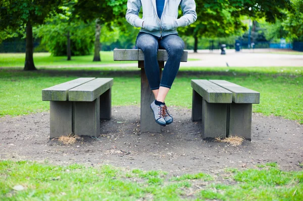 Kvinde sidder på bordet i parken - Stock-foto