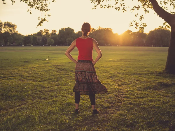Vrouw in park u geniet van de zonsondergang — Stockfoto