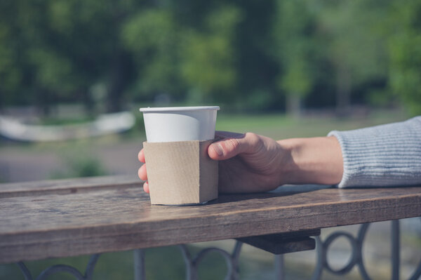 Female hand holding paper cup