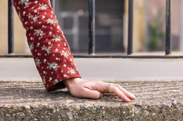 Hand of woman by metal fence — Stock Photo, Image