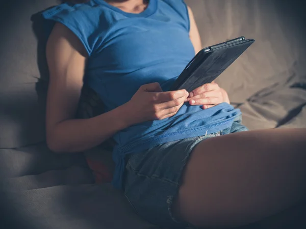 Молодая женщина использует планшет дома — стоковое фото