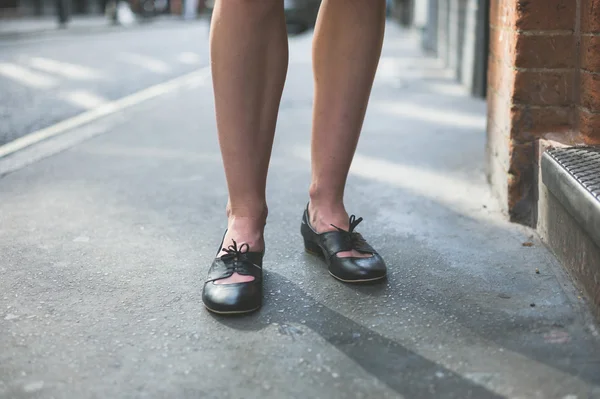 Benen van de vrouw permanent op de stoep — Stockfoto