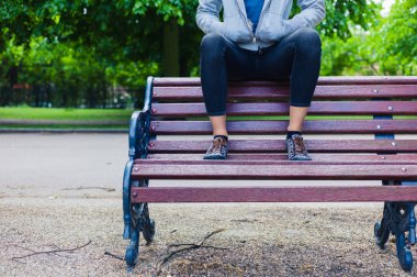 Parktaki bankta oturan genç bir kadın