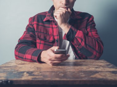 Genç adam akıllı telefon kullanarak tablo yönü