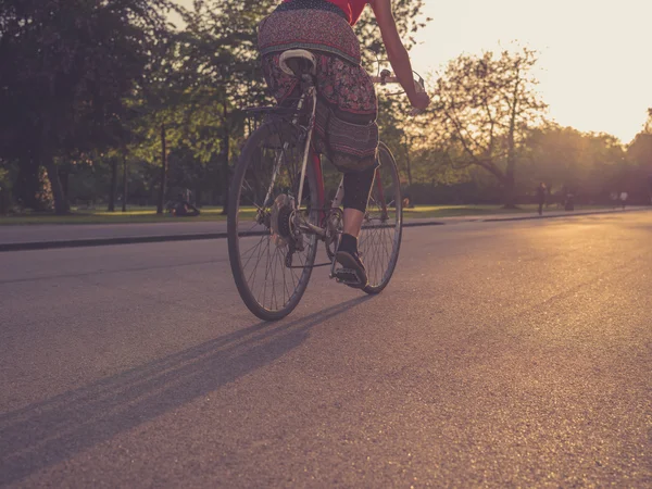 Žena na kole při západu slunce — Stock fotografie