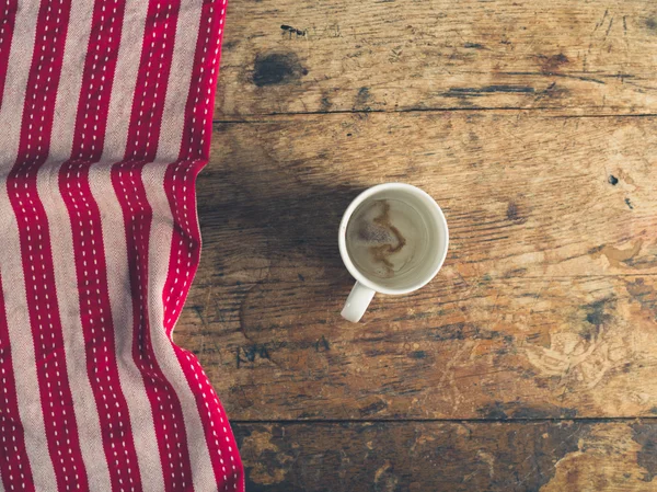 Пустой стакан и полотенце для чая на деревянном столе — стоковое фото