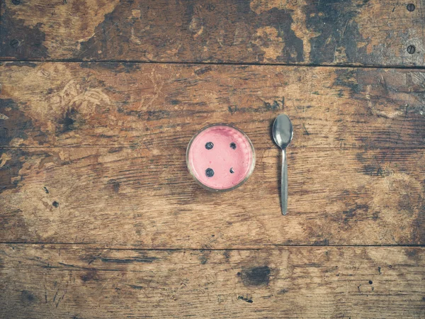 Yogur y cuchara sobre mesa de madera — Foto de Stock