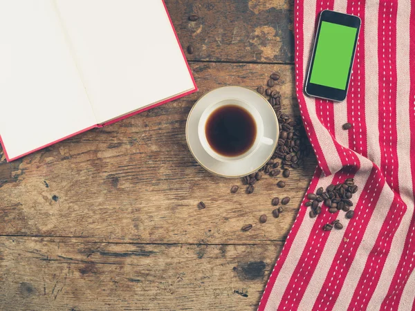 Koffie concept met cup, een boek en een slimme telefoon — Stockfoto