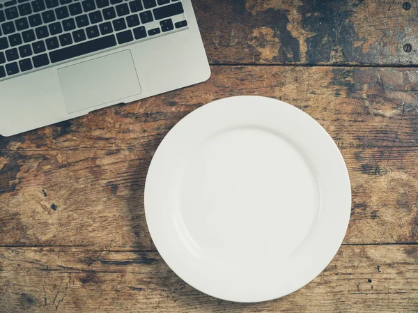 Laptop ve plaka üzerinde ahşap masa