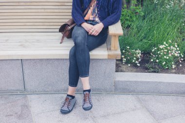 Genç kadın şehirde bankta rahatlatıcı