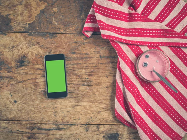 Yoğurt ve tabloda çay havlu ile akıllı telefon