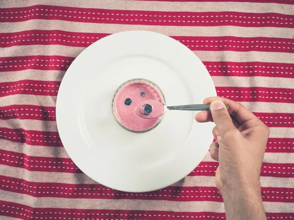 Male hand holding spoon with yogurt — Stock Photo, Image