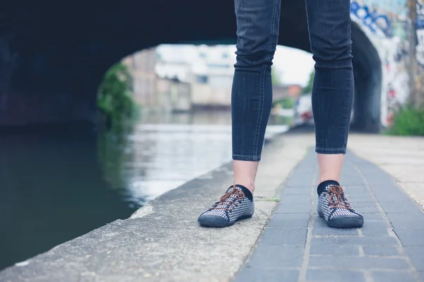 Benen van jonge vrouw door kanaal — Stockfoto