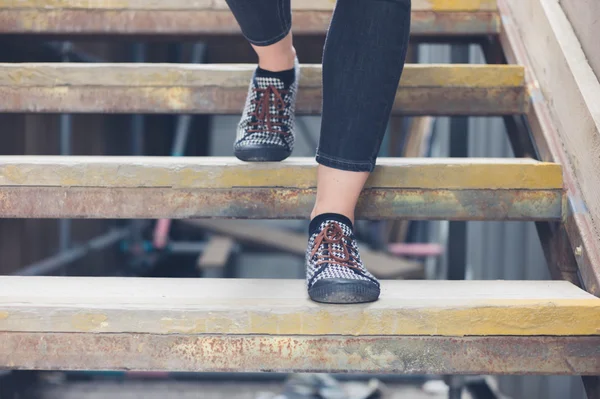 Mujer joven caminando por escalones de madera — Foto de Stock