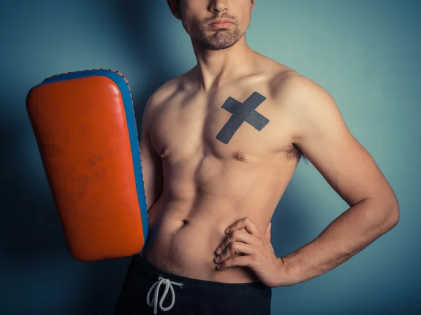 Jovem atlético com almofadas de artes marciais — Fotografia de Stock