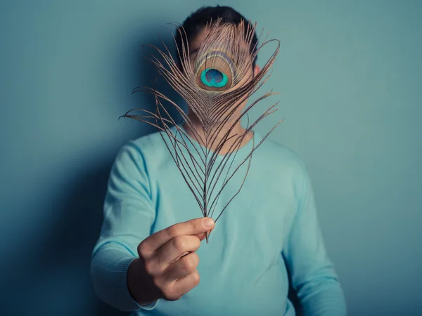 Young man with peacock feather — Stock Photo, Image