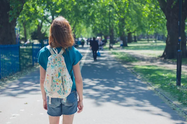 Young woman with backpack in park — Stock Photo, Image